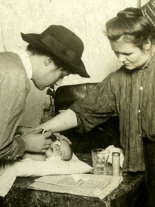 A Visiting Nurse From Henry Street Settlement Treats An Infant In A Tenement Apartment